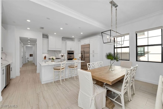 dining area featuring a chandelier, light hardwood / wood-style flooring, and ornamental molding