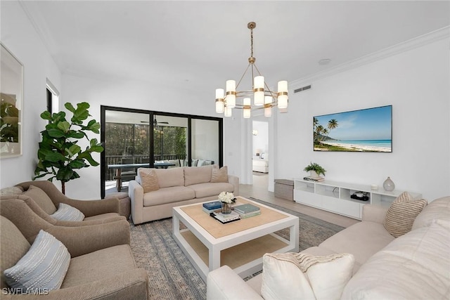 living room featuring ornamental molding, a notable chandelier, and wood-type flooring