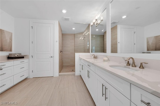 bathroom featuring a tile shower and vanity