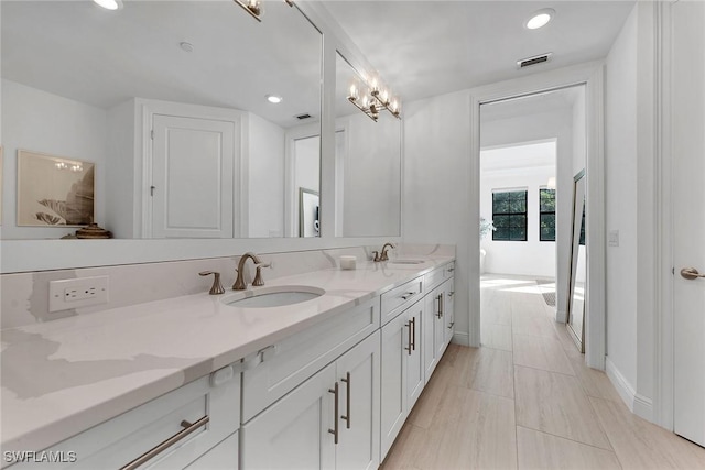 bathroom with a chandelier and vanity