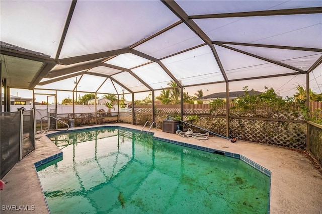 pool at dusk featuring a patio and a lanai