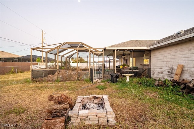 view of yard with an outdoor fire pit and a lanai