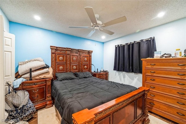 bedroom with ceiling fan, a textured ceiling, and light hardwood / wood-style flooring