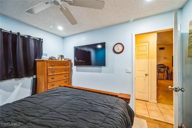 bedroom featuring ceiling fan, a textured ceiling, and light hardwood / wood-style flooring