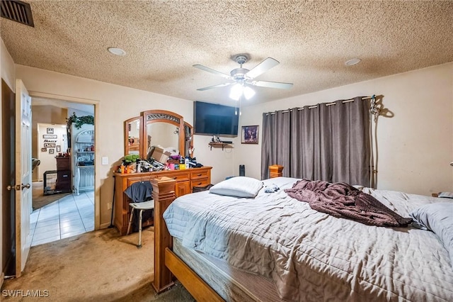 carpeted bedroom featuring ceiling fan and a textured ceiling