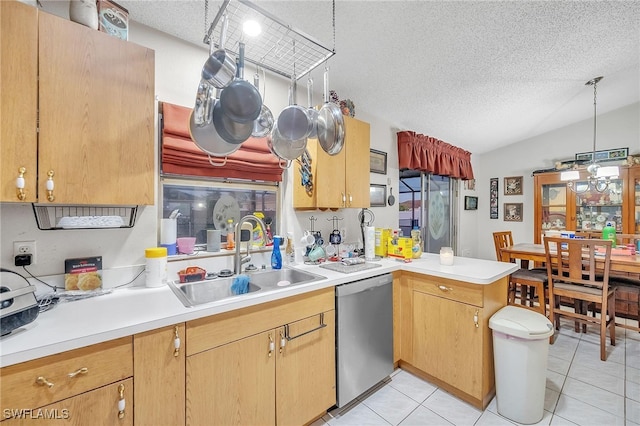 kitchen featuring kitchen peninsula, stainless steel dishwasher, a textured ceiling, sink, and decorative light fixtures