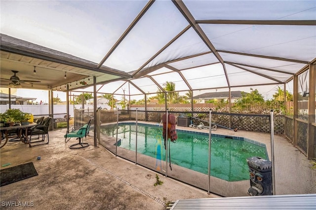 view of swimming pool with glass enclosure and a patio