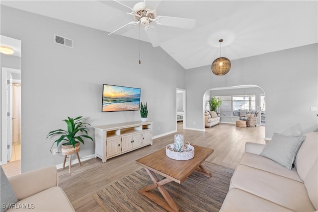 living room with ceiling fan, high vaulted ceiling, and light wood-type flooring