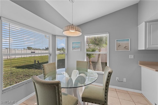 dining space featuring vaulted ceiling and light tile patterned floors