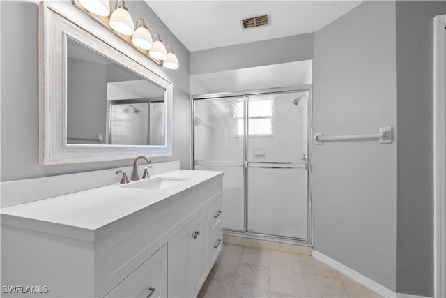 bathroom with vanity and a shower with door