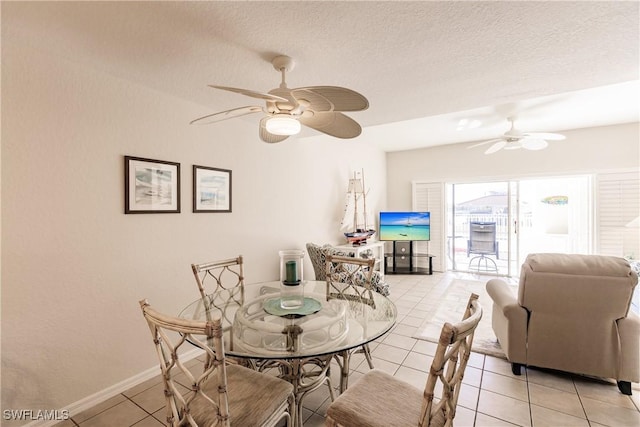 dining area with ceiling fan, light tile patterned flooring, and a textured ceiling