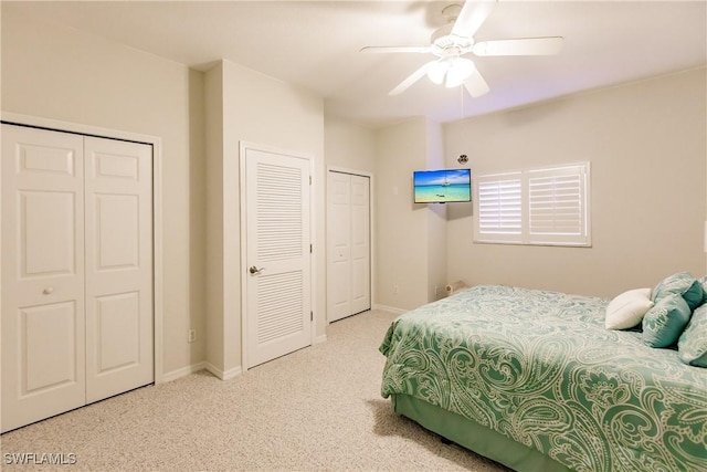 carpeted bedroom with two closets and ceiling fan