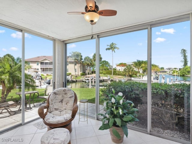 sunroom / solarium with a water view and ceiling fan