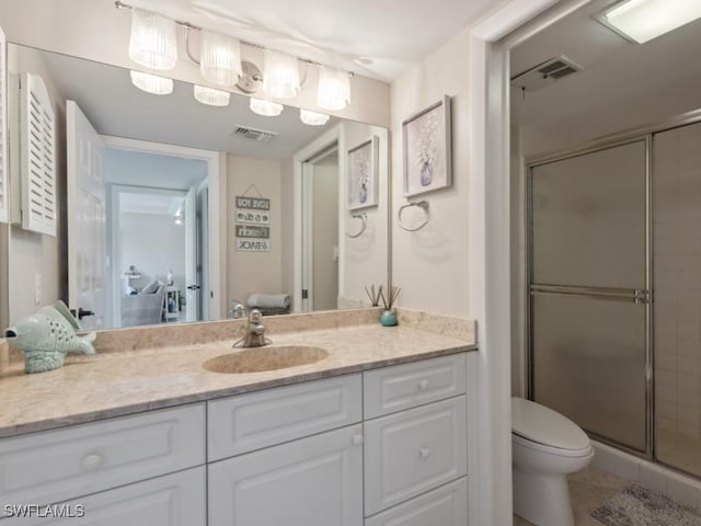 bathroom featuring tile patterned flooring, vanity, toilet, and walk in shower