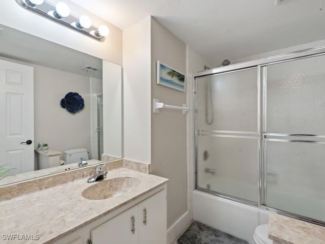 full bathroom with vanity, toilet, and bath / shower combo with glass door