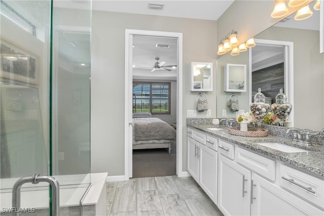 bathroom with ceiling fan, a shower with door, and vanity