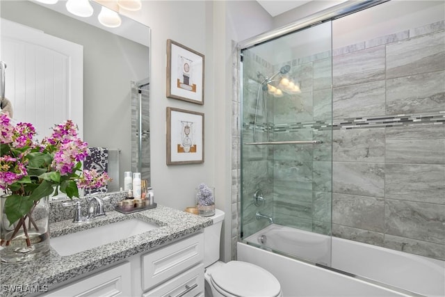 full bathroom featuring vanity, bath / shower combo with glass door, and toilet