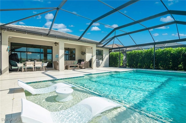 view of swimming pool with ceiling fan, a patio area, a lanai, and an outdoor hangout area