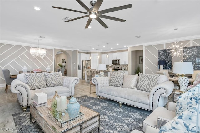 living room featuring ceiling fan with notable chandelier and ornamental molding