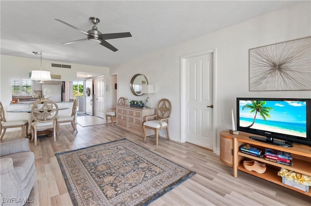 living room featuring light wood-type flooring and ceiling fan