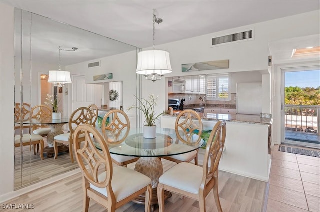 dining space featuring sink and light wood-type flooring