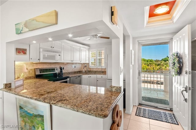 kitchen featuring stone counters, kitchen peninsula, ceiling fan, appliances with stainless steel finishes, and white cabinetry