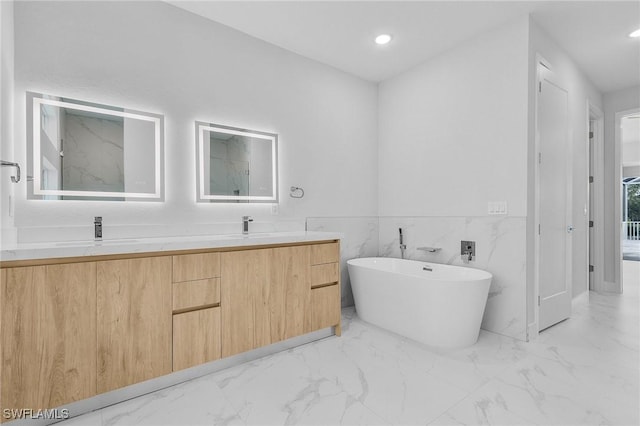 bathroom with vanity, a bath, and tile walls