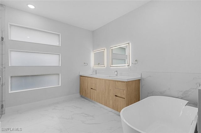 bathroom with a washtub and vanity