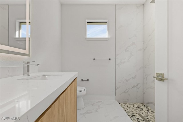 bathroom featuring vanity, toilet, and tiled shower