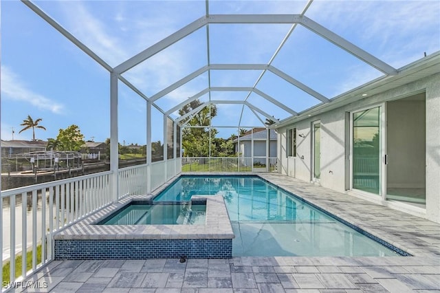 view of swimming pool with an in ground hot tub, a patio, and glass enclosure