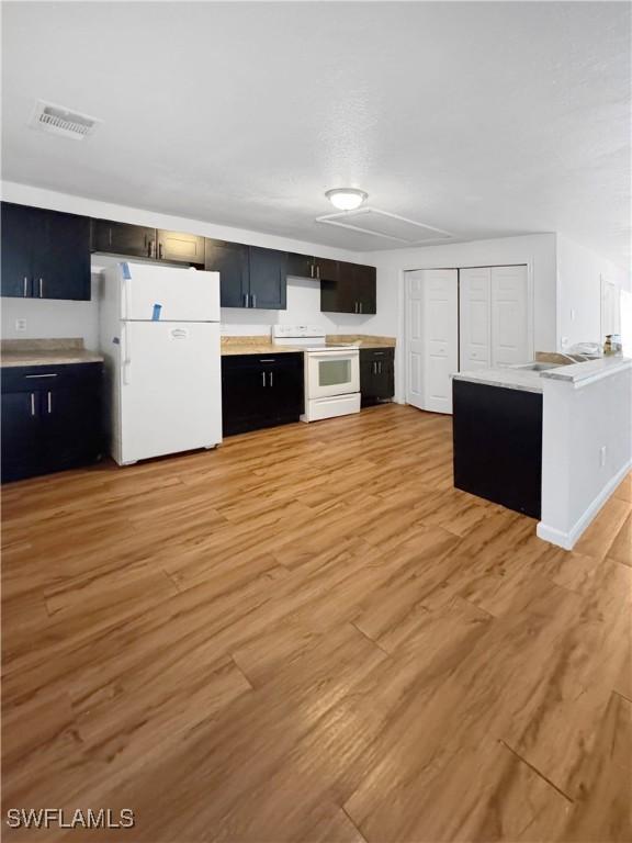 kitchen with white appliances and light hardwood / wood-style flooring