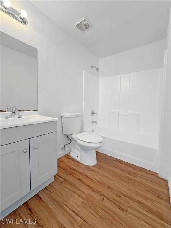 full bathroom with vanity, wood-type flooring, bathtub / shower combination, and toilet