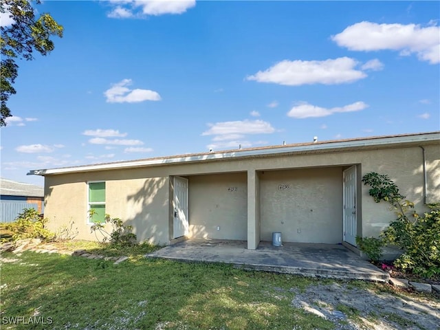 rear view of house featuring a lawn and a patio area