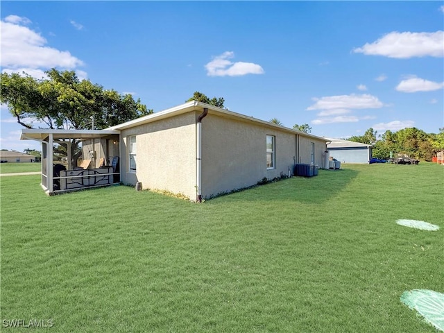 view of side of property featuring central AC unit and a lawn