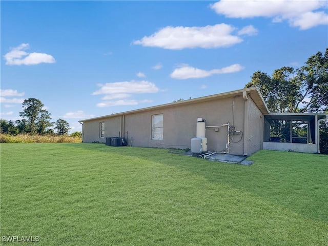 back of house with central AC, a sunroom, and a yard