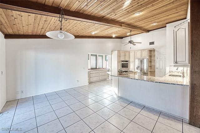 kitchen with light stone countertops, sink, stainless steel appliances, lofted ceiling with beams, and kitchen peninsula