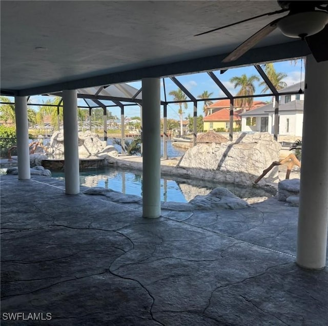 view of patio / terrace with glass enclosure and a water view