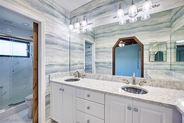 bathroom with vanity, ceiling fan, a shower with door, tile walls, and toilet