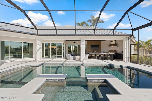 back of property with exterior bar, a patio, glass enclosure, and ceiling fan