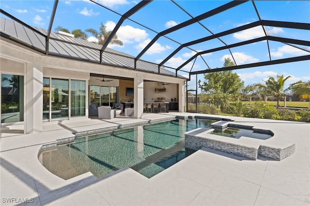 view of swimming pool with an in ground hot tub, ceiling fan, glass enclosure, a patio area, and an outdoor bar