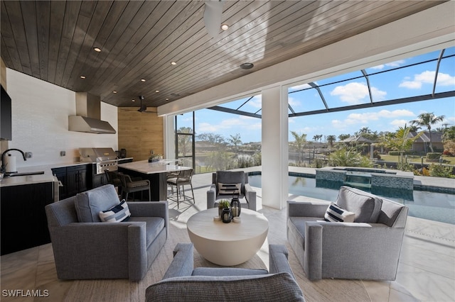 view of patio with a wet bar, exterior kitchen, a swimming pool with hot tub, glass enclosure, and grilling area