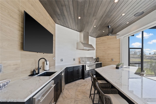 kitchen featuring sink, dishwasher, wall chimney range hood, light stone counters, and wood ceiling