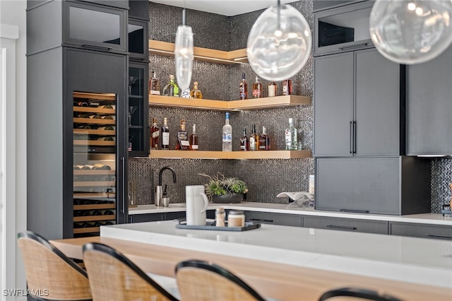 bar with pendant lighting and backsplash