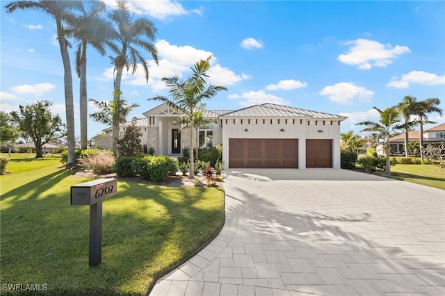 view of front of property featuring a front yard and a garage