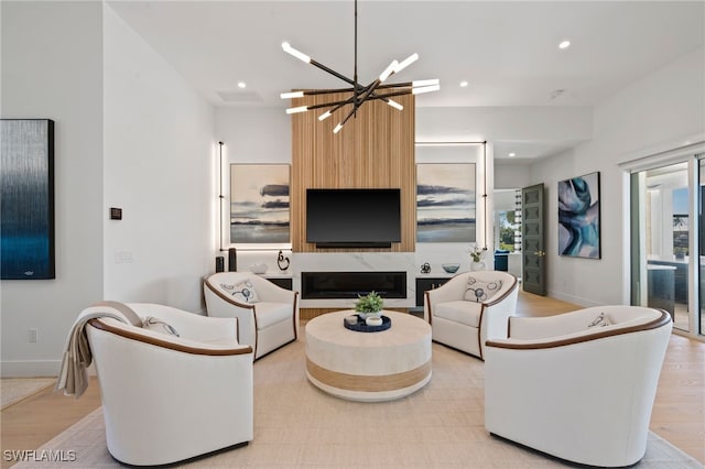 living room featuring a chandelier, light wood-type flooring, and a fireplace