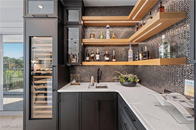 bar featuring backsplash, sink, and hardwood / wood-style floors