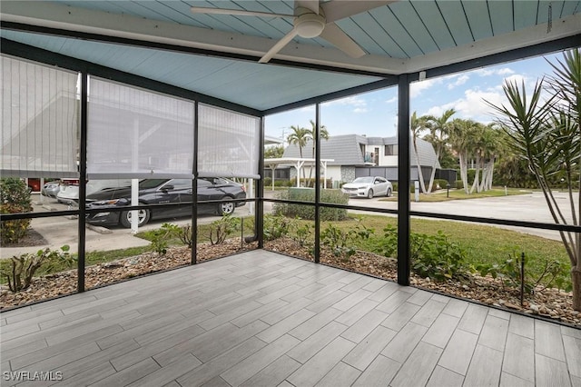 unfurnished sunroom featuring ceiling fan