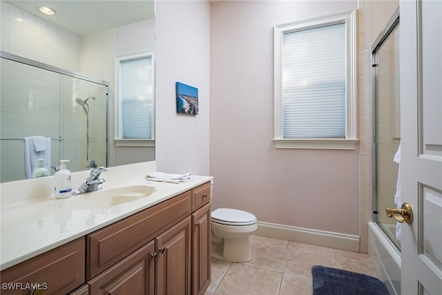 full bathroom featuring tile patterned flooring, vanity, toilet, and shower / bath combination with glass door