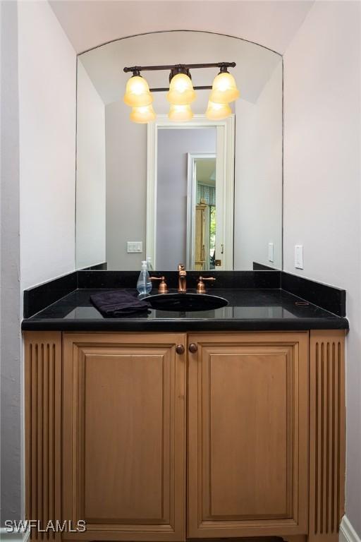 bathroom featuring vanity and lofted ceiling