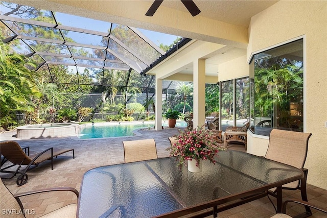 view of patio with glass enclosure, ceiling fan, and a pool with hot tub